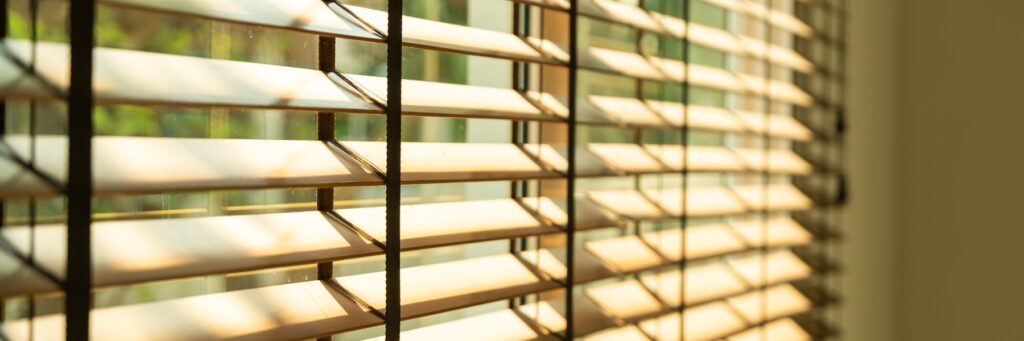 Close-up of wood blinds filtering sunlight