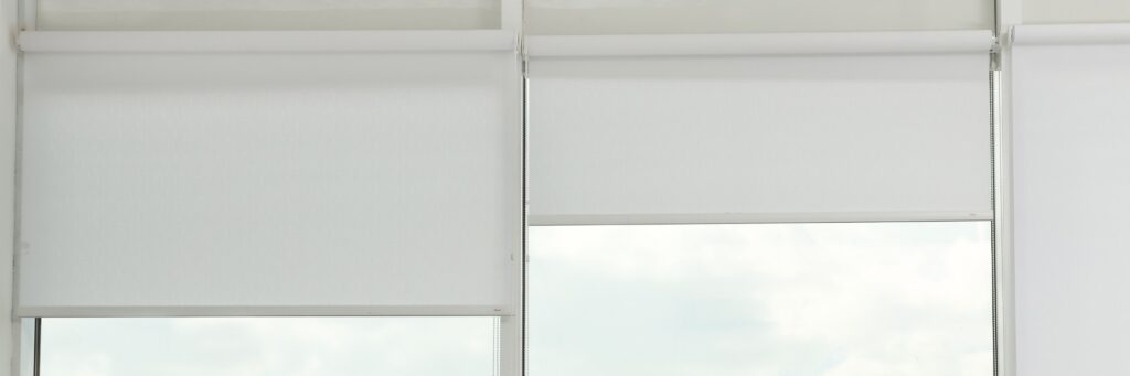 White roller shades on tall windows