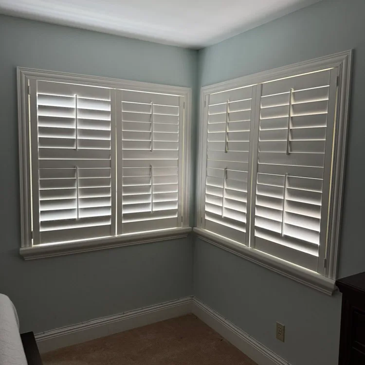White plantation shutters with tilted louvers on corner windows